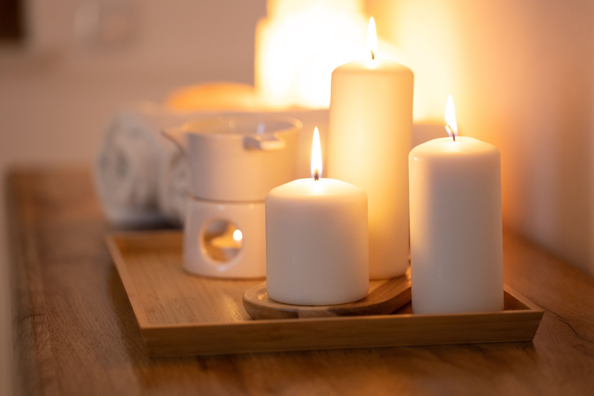 Atmospheric, burning candles and an essential oil warmer, creating a warm, relaxing home spa ambiance